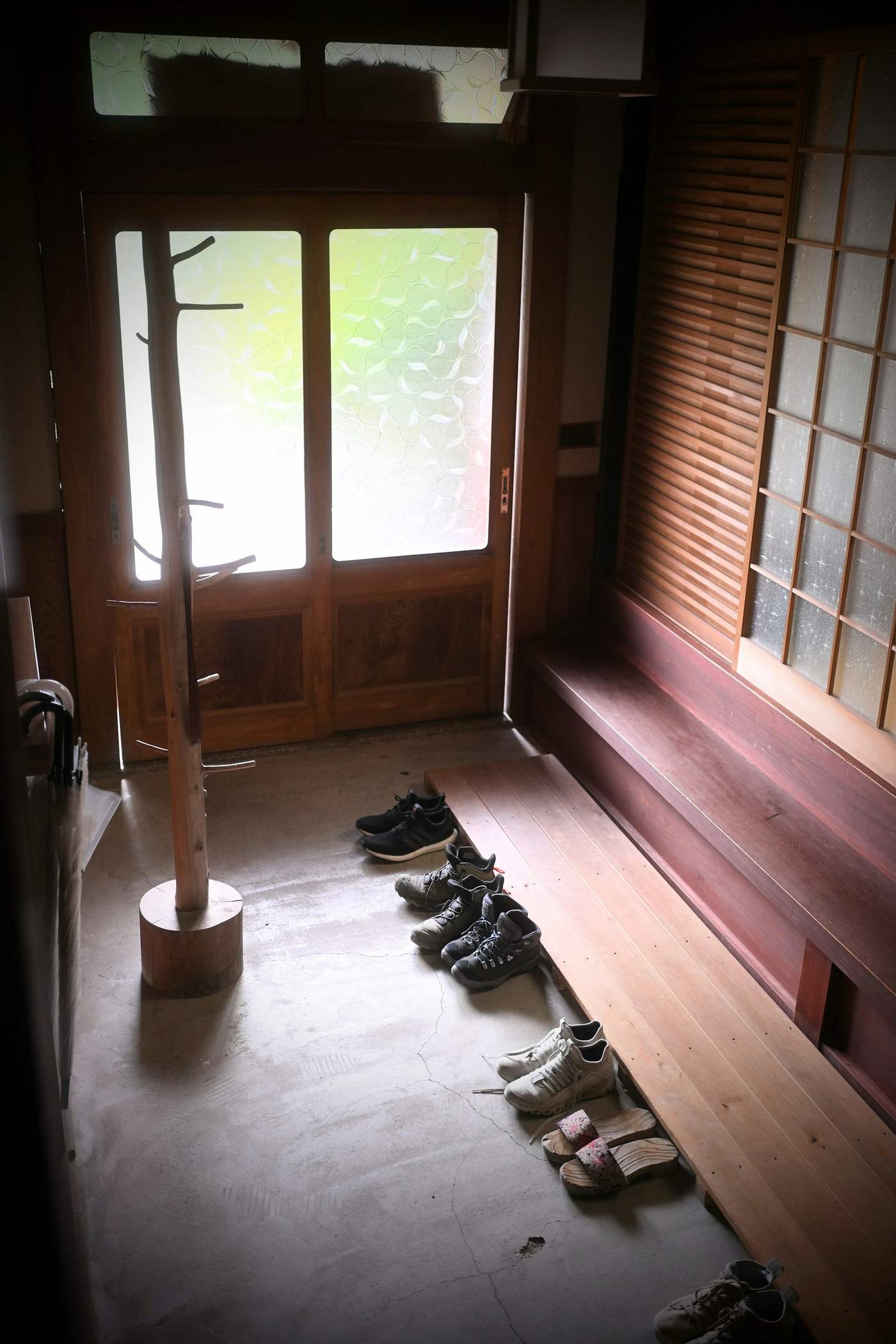 木の上がり框と土間のある玄関。すりガラスの戸から光が入る